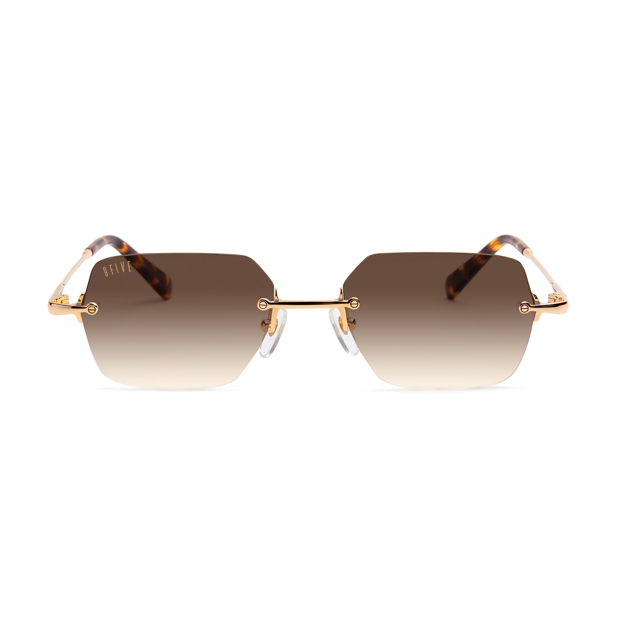 Hexagonal rimless sunglasses with gradient brown lenses, gold metal frames, and tortoiseshell temples, shown against a plain white background.[g:brown-gradient s:all o:1]