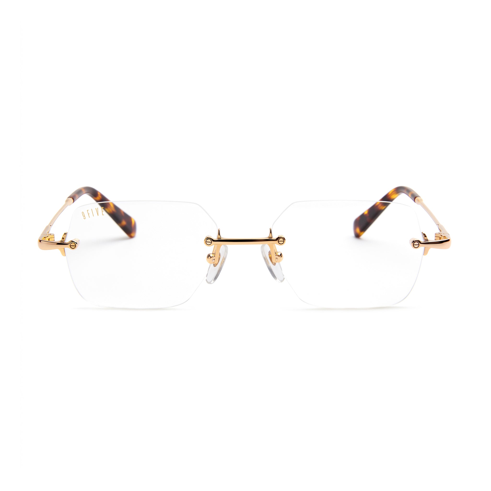 Rimless eyeglasses with clear lenses, gold metal bridge and hinge details, and tortoiseshell temples on a white background.