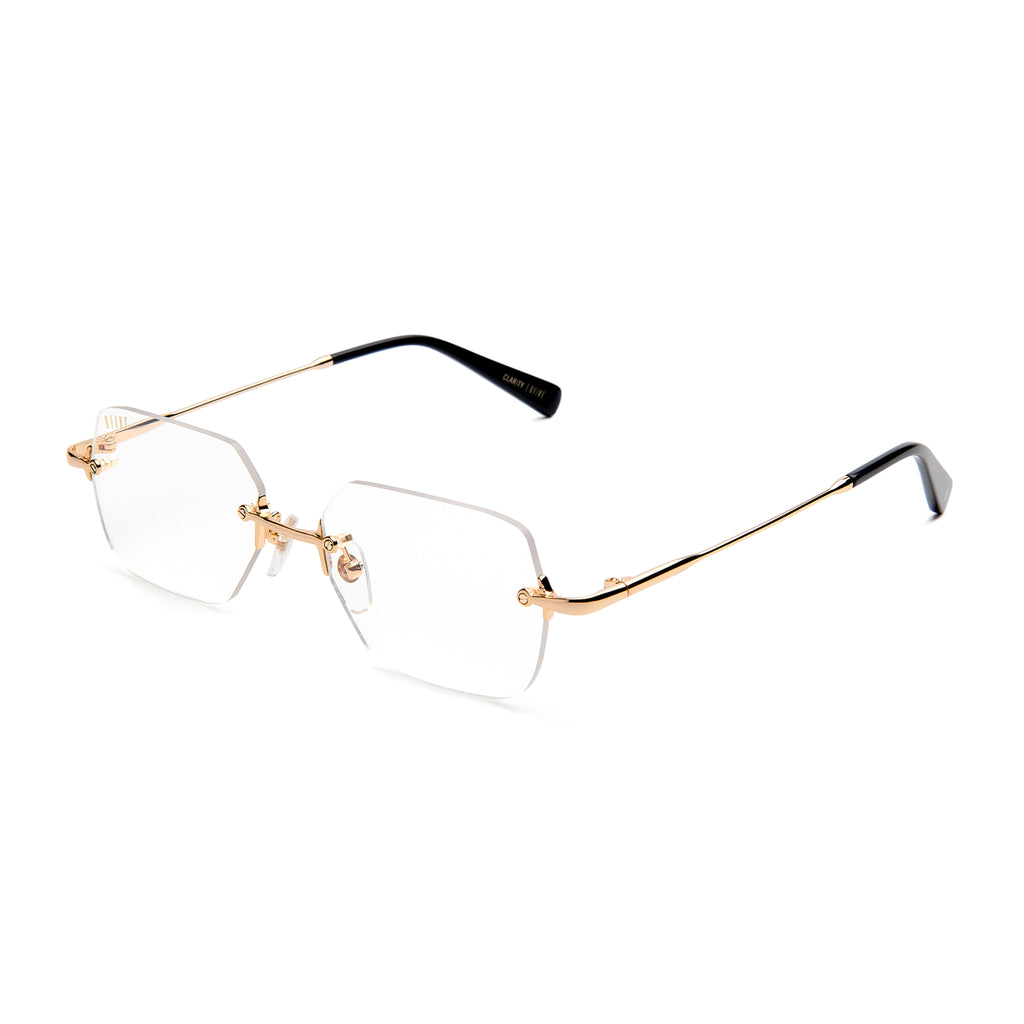 Rimless square eyeglasses with a gold metal frame and clear lenses, shown at an angle on a white background.