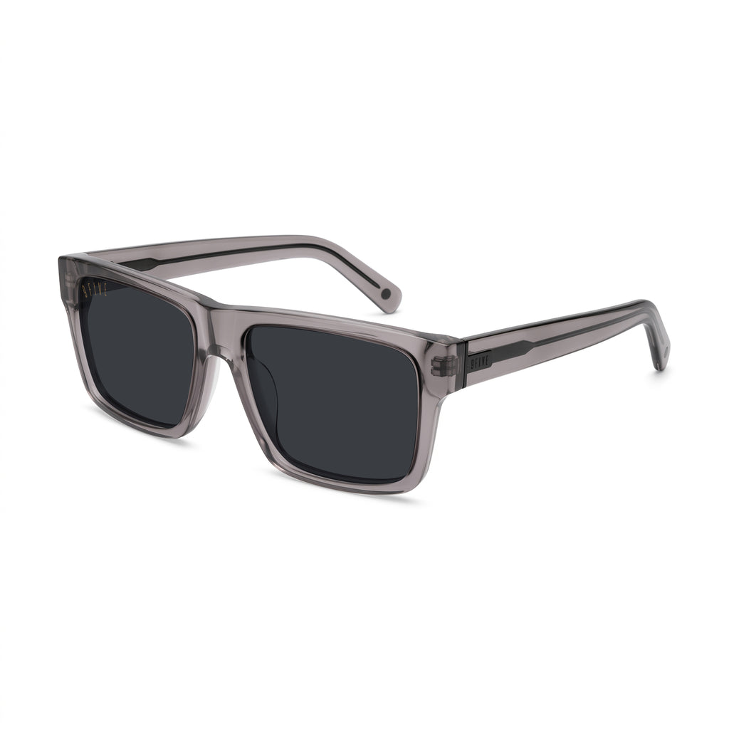 A pair of square sunglasses with a translucent smoky gray acetate frame and dark gray lenses, shown at a three-quarter angle on a plain white background.
[g:black s:all o:2]