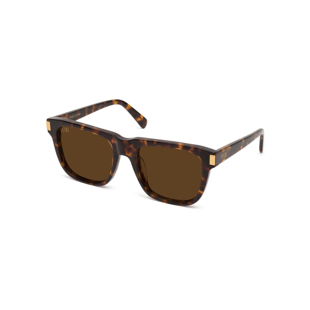 Square sunglasses with a dark brown and amber tortoiseshell frame and brown lenses, featuring small gold metal accents on the temples, shown against a plain white background. [g:brown s:all o:2]