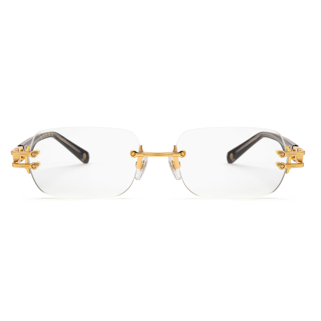 Rimless eyeglasses with clear lenses, gold metal hardware, and dark tortoiseshell temples on a white background. [g:clear s:all o:1]
