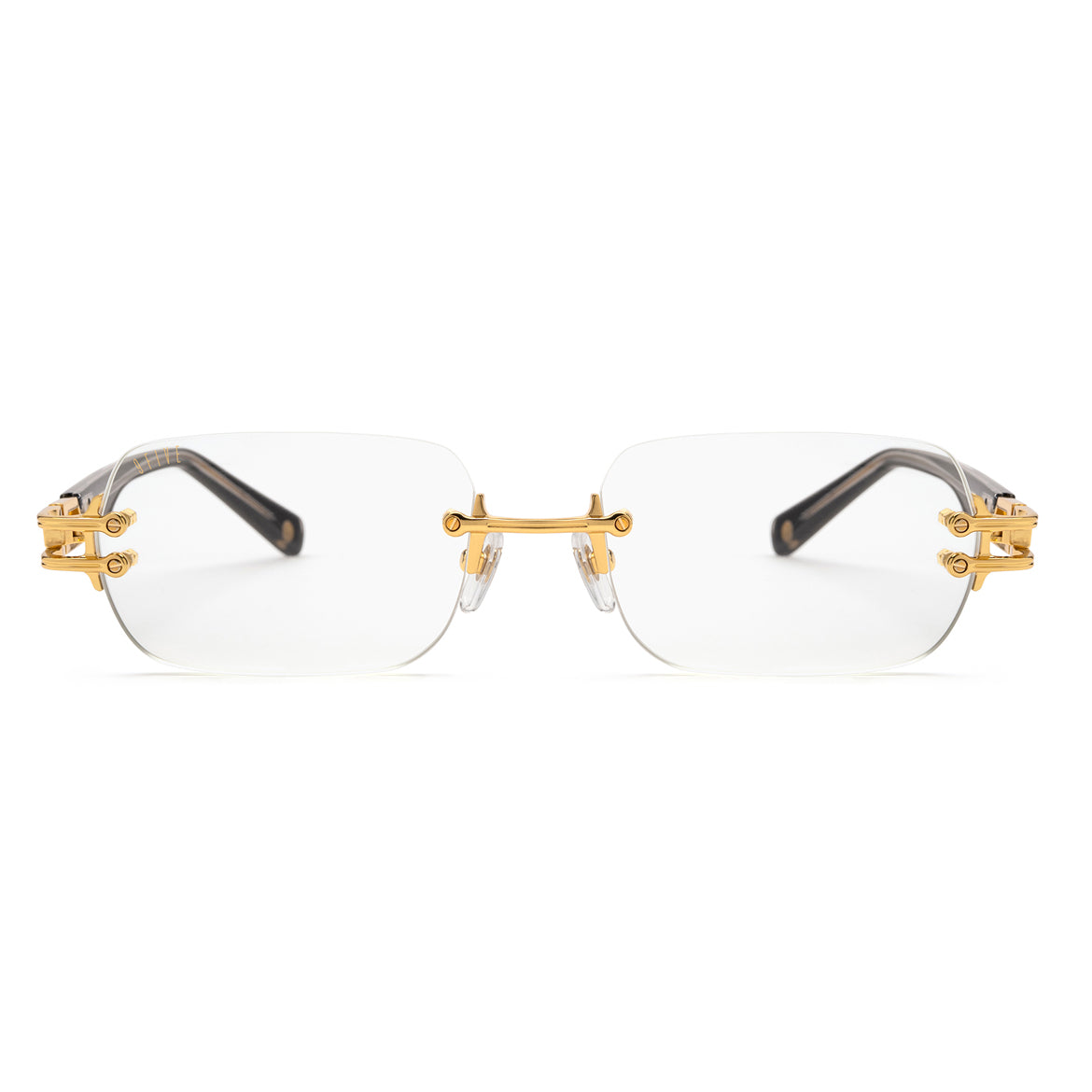 Rimless eyeglasses with clear lenses, gold metal hardware, and dark tortoiseshell temples on a white background. [g:clear s:all o:1]