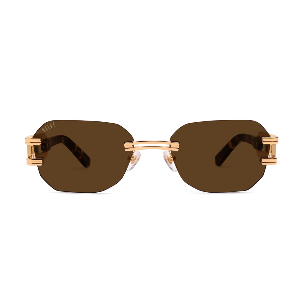 Rimless square sunglasses with dark brown lenses and gold metal frames, featuring decorative gold hardware on the temples, shown against a plain white background. [g:brown s:all o:1]