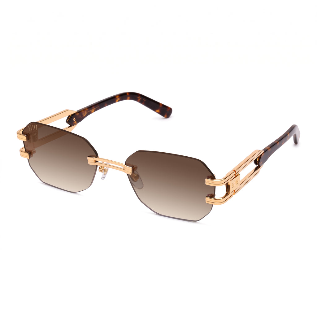 Rimless geometric sunglasses with gradient brown lenses, gold metal frames, and tortoiseshell temple arms, shown on a plain white background. [g:brown-gradient s:all o:2]