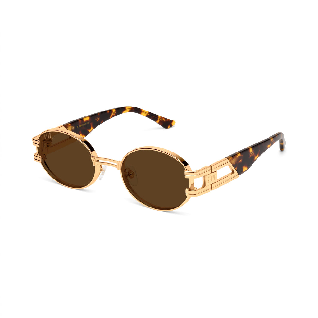 Oval sunglasses with gold metal frames, brown gradient lenses, and tortoiseshell acetate temples, shown on a clean white background. [g:brown s:all o:2]
