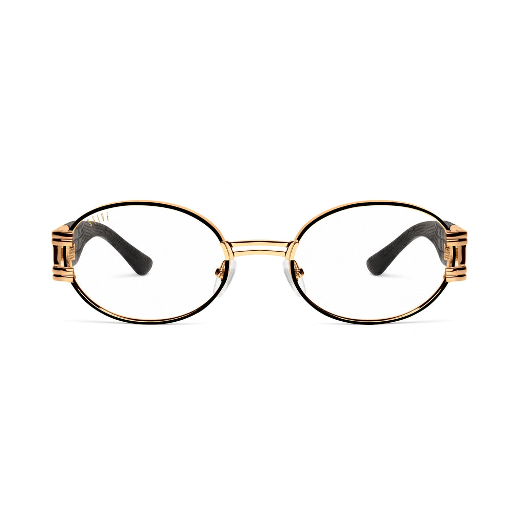 Oval sunglasses with clear lenses, a gold metal frame, and black temple tips, shown against a plain white background.[g:clear s:all o:1]