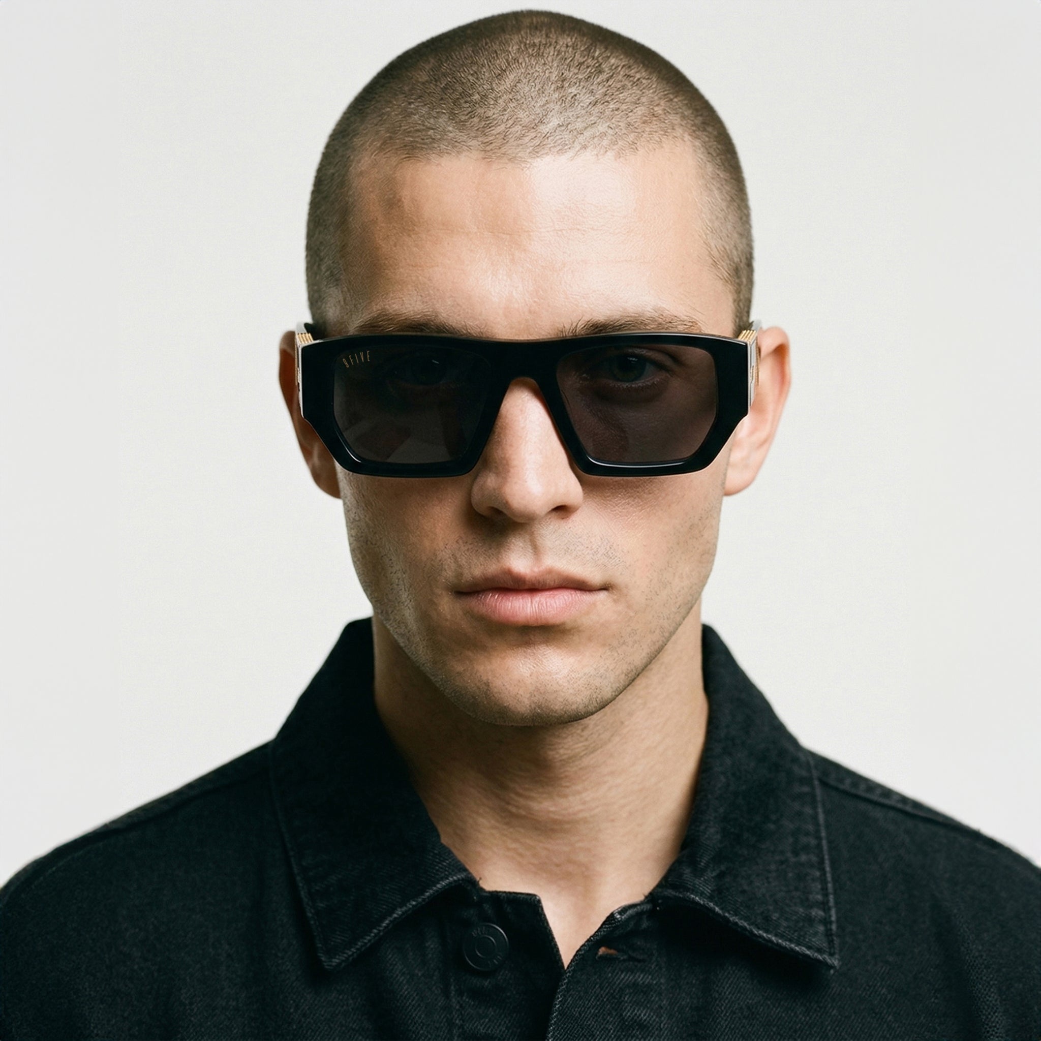Man wearing black sunglasses and a dark shirt against a light background [g:black s:all o:4]